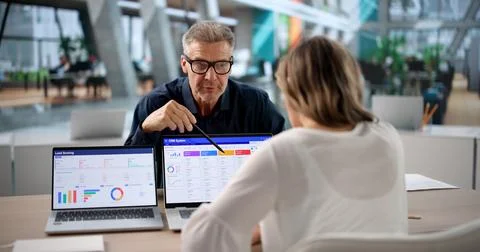 Two Sales Leaders Reviewing CRM Software Features On Laptop Together. Stockfoto's