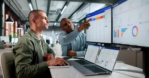 Two Sales Managers Use CRM Software On Laptops To Analyze Customer Data Toget Stock Photos