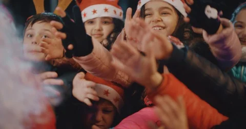 Two Santa Clauses Helping Each Other To Give Gifts To Crowd, Queue Of Children . Stock Footage 120571335