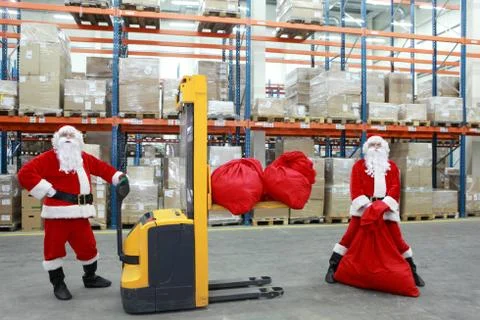 Two santa clauses workers at work in large storehouse Stock Photos