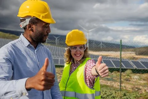 Two satisfied engineers in a solar power plant at work show the thumbs up, .. Stock Photos