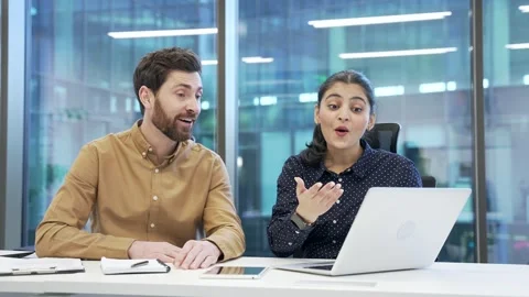 Two satisfied happy co-workers celebrate success at work using laptop. Smiling  Stock Footage 309011345