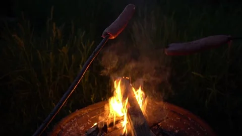 Two sausages are fried on a fire Видео 136422939