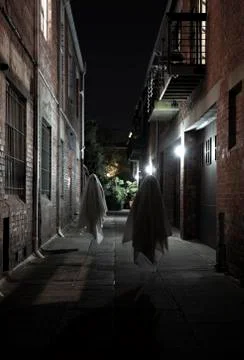 Two scary ghosts floating in between buildings at night Stock Photos