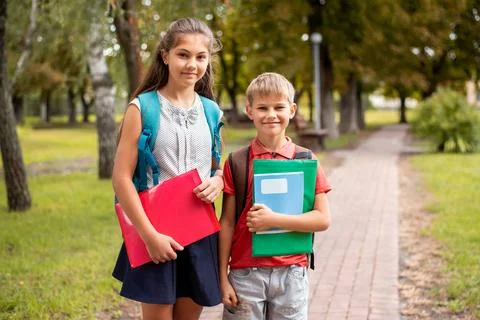 Two school learners of different age going to school Stock Photos