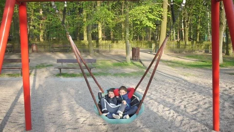 Two schoolchildren ride on a swing Stock Footage 115098871