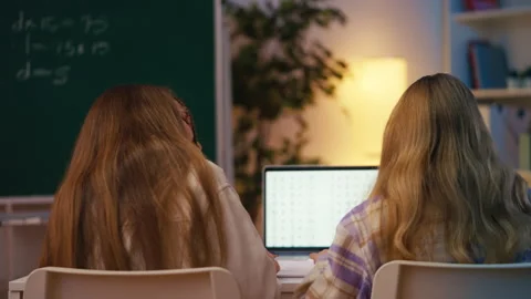 Two schoolgirls write their test answers in notebooks during a math lesson Stock Footage 300277151