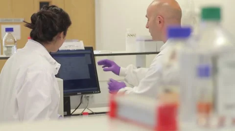 Two Scientist looking at test results on computer screen in laboratory Stock Footage