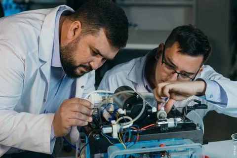 Two scientists are working on the development of a new device Stock Photos