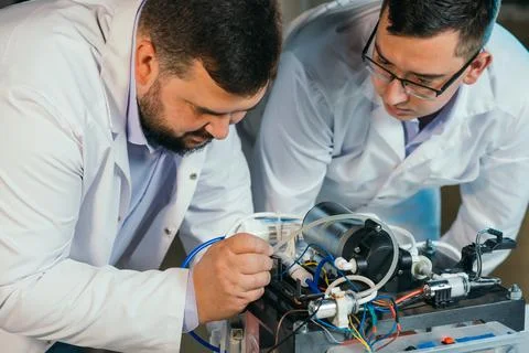 Two scientists are working on the development of a new device Stock Photos