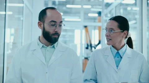 Two Scientists Discussing Research Data while Walking in Laboratory Видео 331336717
