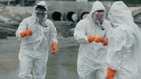 Two scientists in full hazmat suits examine polluted water 库存影片 346120321