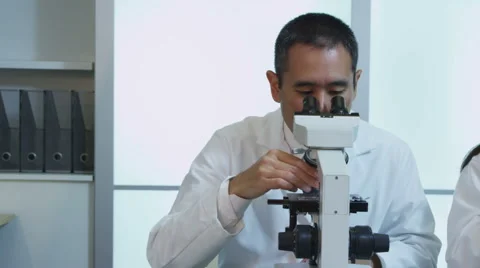 Two scientists look into microscopes Stock Footage 62281896