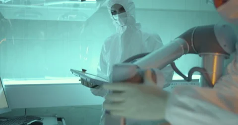 Two scientists prepare robot arm in clean room Stock Footage 232901339
