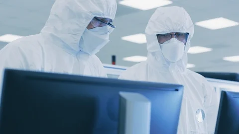 Two Scientists/ Technicians in Sterile Suits Check Data on Personal Computer. 스톡 동영상 93226457