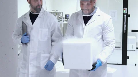 Two Scientists transporting dry ice in laboratory Stock Footage 296886163