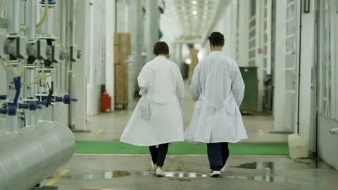 Two scientists walking along corridor 스톡 동영상 96584104