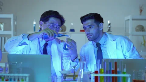 Two scientists were pouring material into a test tube Stock Footage 141000881