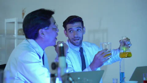 Two scientists were pouring material into a test tube and recording the results. Stock Footage 141001318