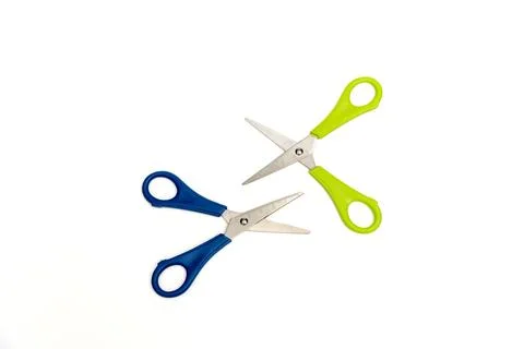 Two scissors, one blue and one green, are sitting on a white background Stock Photos