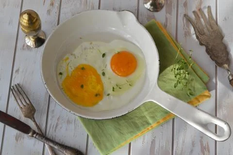 Two scrambled eggs in a frying pan on a white background Stock Photos