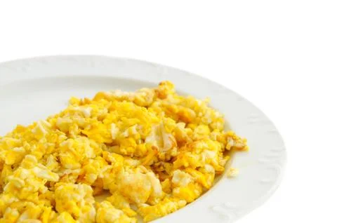 Two scramled eggs isolated on white background on a white plate. Stock Photos