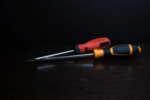 Two screwdrivers of different colors with reflection Stock Photos