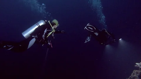 Two scuba divers man and woman swims in the deep blue water, Indian Ocean, Stock Footage 89574115