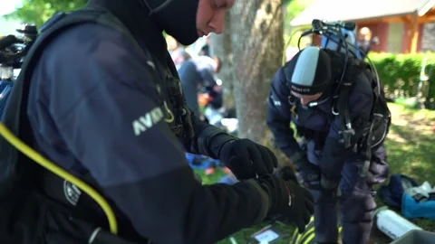 Two scuba divers prepare their equipment on the shore of Attersee in Austria Видео 331350501