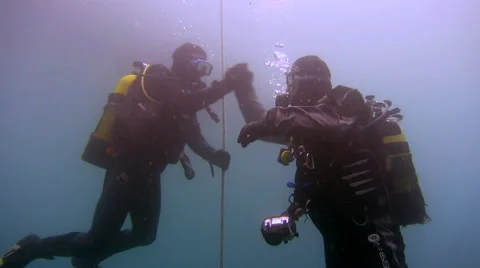 Two scuba divers shake hands and hug Stock Footage 48586374