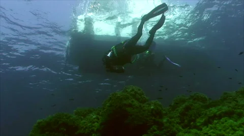 Two scuba divers swimming under dive boat, mediterranean sea Stock Footage 43216129