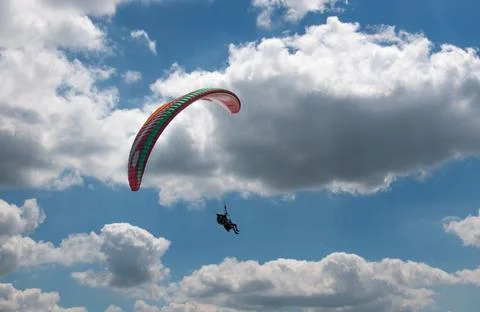 Two seated paraglider flying is cloudy sky Stock Photos