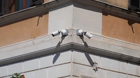 Two security cameras watch a Roman corner building silently Stock Footage 306320378