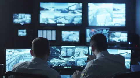 Two security officers noticed a trespasser on a surveillance computer screen Stock Footage