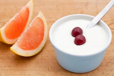 Two segments of pink grapefruit and fresh jogurt Stock-Fotos