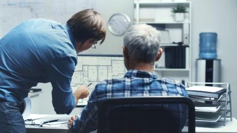 Two Senior Architectural Engineers Working With Building Plan on a Personal C Fotos de archivo