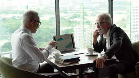 Two senior businessman take a break drinking coffee and discussing business s Stock Footage 158522091