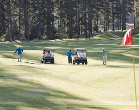 Two senior couples playing golf on a golf course. Fotos de archivo