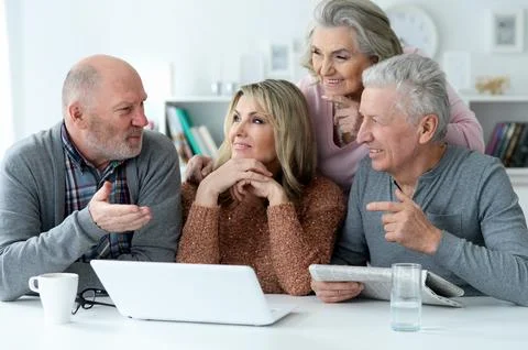 Two senior couples sitting at table Stock Photos