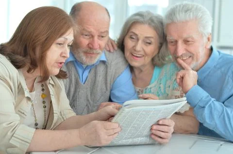 Two senior couples sitting at table Stock Photos