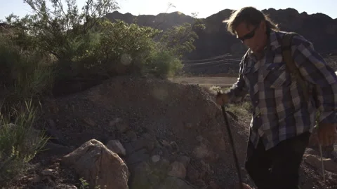 Two senior is hiking at rocks area during sunshine weather. Stock Footage 252783014
