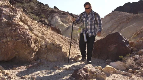 Two senior is hiking at rocks area during sunshine weather. Stock Footage 252783473