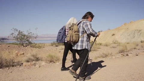 Two senior is hiking at rocks area during sunshine weather. Stock Footage 252792913
