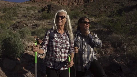Two senior is hiking at rocks area during sunshine weather. Stock Footage 252851359