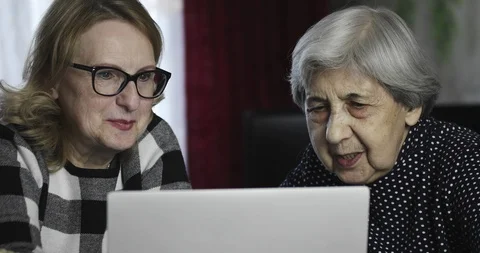 Two senior women communicate through the Internet on the computer. Stock Footage 109568277