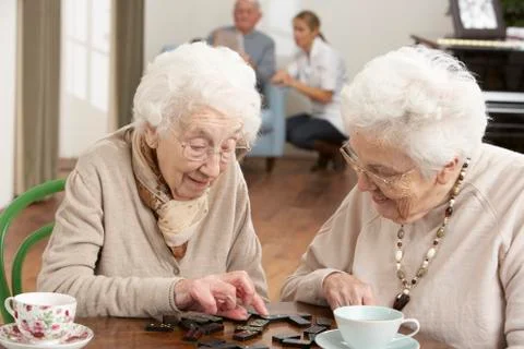 Two Senior Women Playing Dominoes At Day Care Centre Stock Photos