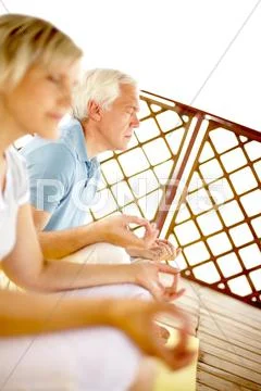 Two seniors mediating on veranda, the focus is on man Stock Photos