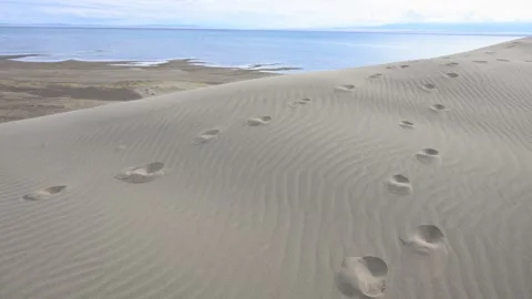 Two separate trails of footprints on a s... | Stock Video | Pond5