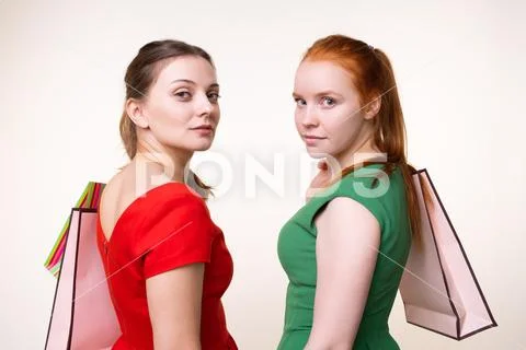 Two serious attractive young women holding paper bags Stock Photos