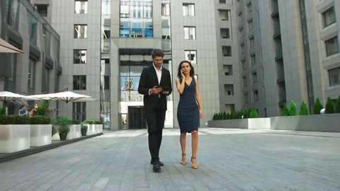 Two serious business colleagues walking on the street, woman talking on phone Stock Footage 73813573